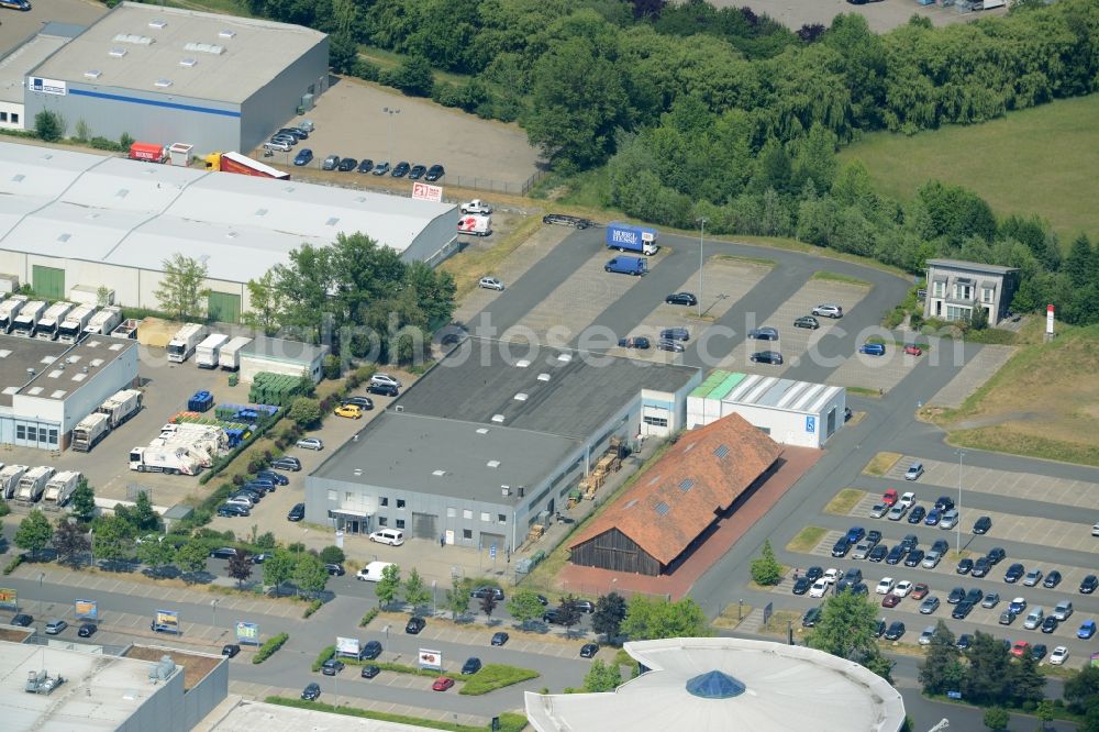 Garbsen from above - Commerce area Garbsen-East in Garbsen in the state of Lower Saxony. The commercial area includes several halls, storage facilities, company buildings and parking lots. It is located adjacent to a field in the East of the town centre