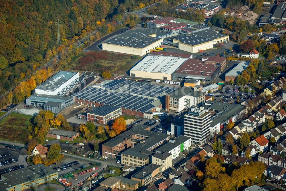 Aerial photograph Neheim - Industrial estate and company settlement on Moehnestrasse in the North of in Neheim in the state of North Rhine-Westphalia. The commercial area is located on the edge of an autumnal forest