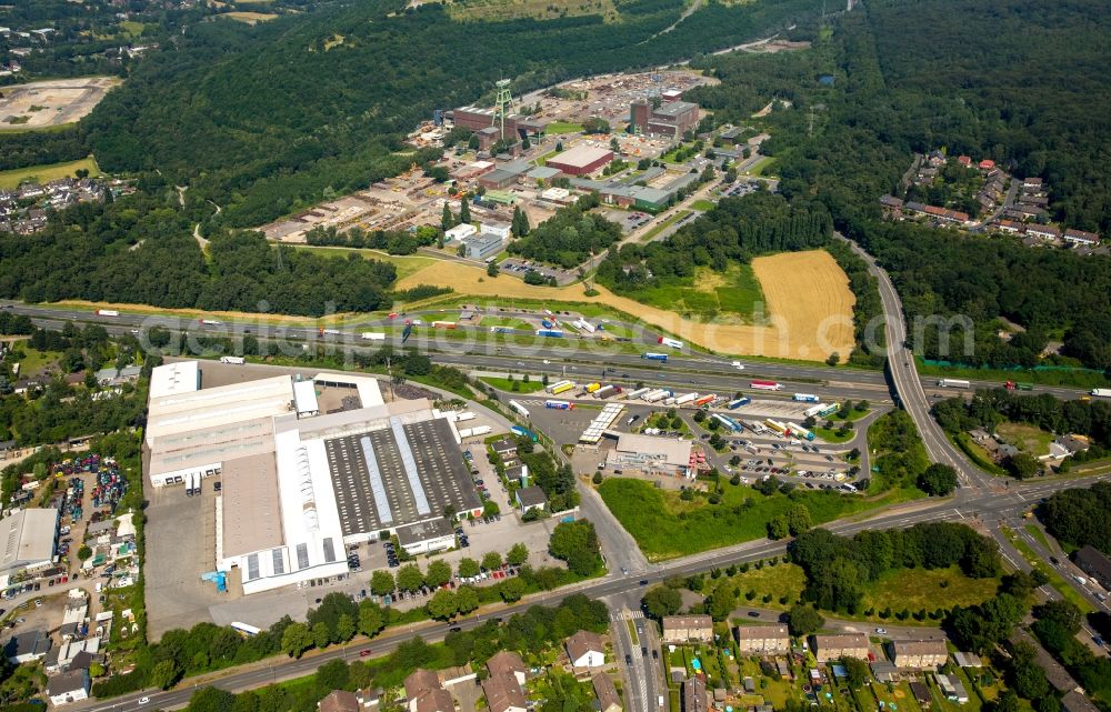 Bottrop from the bird's eye view: Commercial area, companies and truck stop BAB Tank- und Rasthof Bottrop Sued on federal motorway - Autobahn - A2 in Bottrop in the state of North Rhine-Westphalia. The mine Prosper-Haniel is located in the background