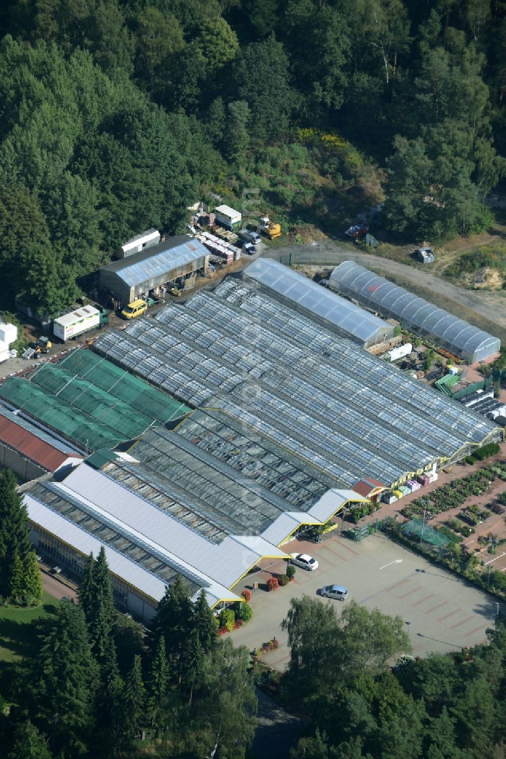 Petershagen from the bird's eye view: Glass houses and gardening store of Gaertnerei Rudolf and Gerd Kolbinger GbR in Petershagen in the state of Brandenburg. The garden-center with its parking lot and different green houses is located on L33, the Altlandsberger Chaussee