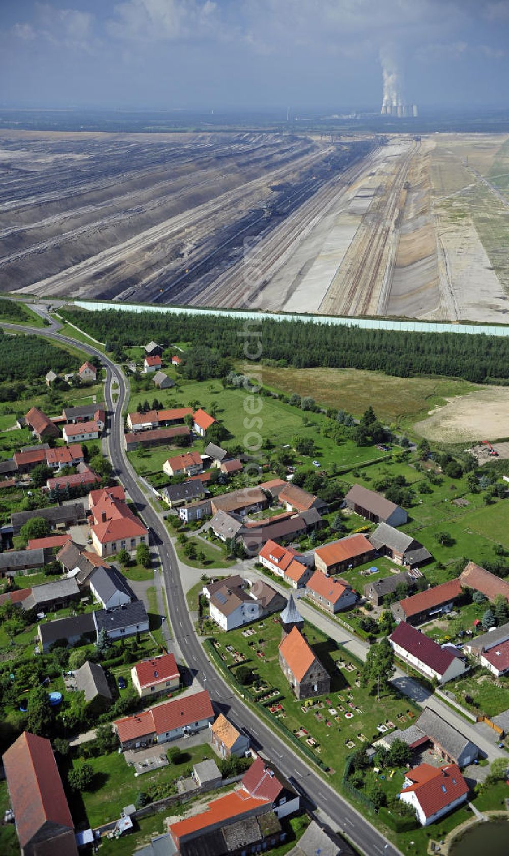 Aerial image Grießen - Blick auf das Dorf Grießen am Braunkohle-Tagebau Jänschwalde. Der Abbau des 8 bis 12 Meter mächtigen Kohleflözes erfolgt durch die Vattenfall Europe Mining AG. Zwischen Tagebau und Dorf wurde ein Grünschutzgürtel angelegt. View of the village Grießen at the lignite-mining Janschwalde. The mining of the 8-12 meters thick coal bed is made by the Vattenfall Europe Mining AG. Between the mine and a the village a green protection belt has been created.