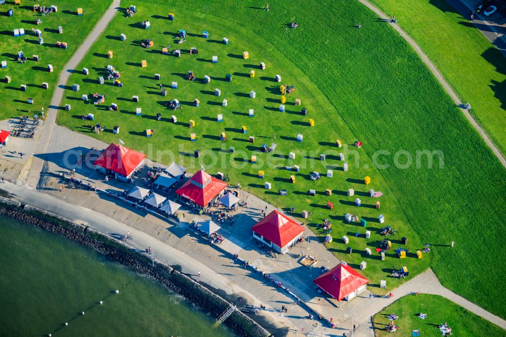 Aerial photograph Cuxhaven - The Grimmershoernbucht with the dike system Doeser Sea dike with beach chairs in the evening sun in Cuxhaven Doese in the state of Lower Saxony