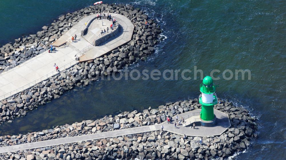 Rostock Warnemünde from above - Der grüne Molenturm am Ende der westlichen Hafenmole von Warnemünde, einem Stadtteil von Rostock in Mecklenburg-Vorpommern, wurde zu Beginn den 1980er Jahren errichtet. In seiner Funktion als Molenfeuer ist der grüne Stahlturm mit weißem Band und zwei Galerien eine Sehenswürdigkeit, die einen guten Blick auf die Stadt und das Warnemünder Seeufer bietet. Green pier tower at western harbour mole of Warnemünde, district of city Rostock in state Mecklenburg-Vorpommern, was constructed in the 1980s. In its role as breakwater light, the green steel tower with two galleries is a site, offering a good view over the city and the lakeshore of Warnemuende.