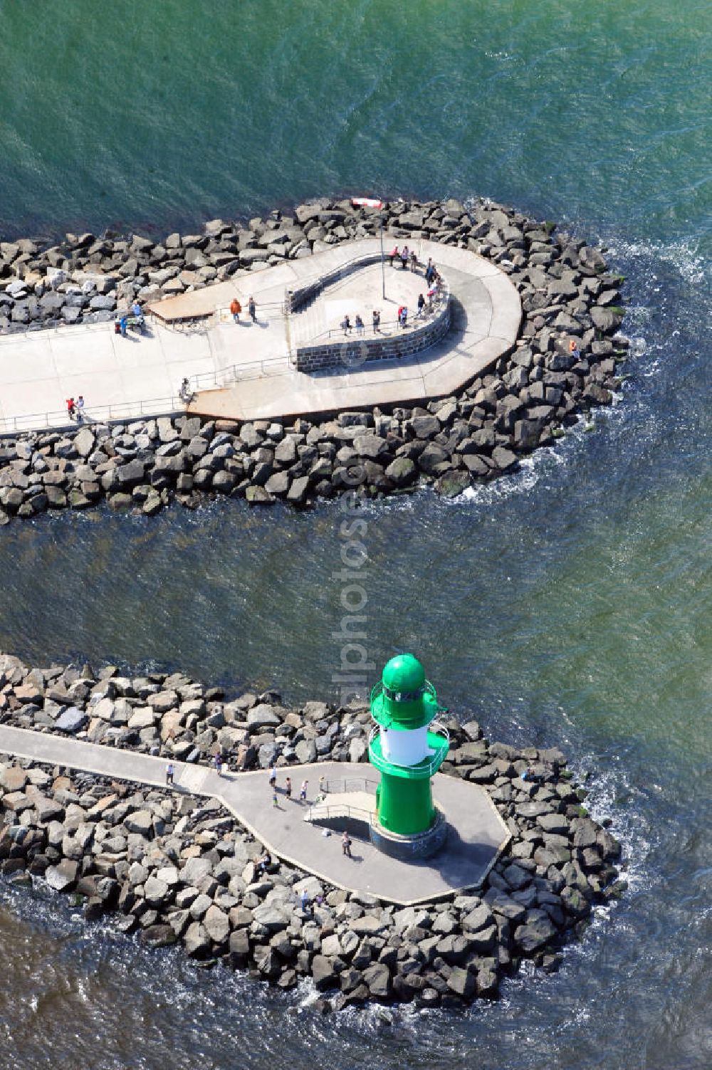 Rostock Warnemünde from the bird's eye view: Der grüne Molenturm am Ende der westlichen Hafenmole von Warnemünde, einem Stadtteil von Rostock in Mecklenburg-Vorpommern, wurde zu Beginn den 1980er Jahren errichtet. In seiner Funktion als Molenfeuer ist der grüne Stahlturm mit weißem Band und zwei Galerien eine Sehenswürdigkeit, die einen guten Blick auf die Stadt und das Warnemünder Seeufer bietet. Green pier tower at western harbour mole of Warnemünde, district of city Rostock in state Mecklenburg-Vorpommern, was constructed in the 1980s. In its role as breakwater light, the green steel tower with two galleries is a site, offering a good view over the city and the lakeshore of Warnemuende.