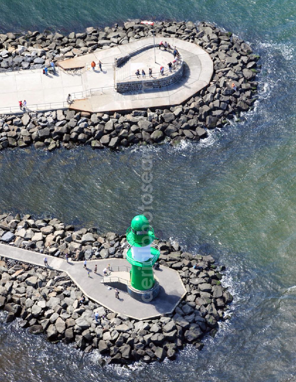 Aerial image Rostock Warnemünde - Der grüne Molenturm am Ende der westlichen Hafenmole von Warnemünde, einem Stadtteil von Rostock in Mecklenburg-Vorpommern, wurde zu Beginn den 1980er Jahren errichtet. In seiner Funktion als Molenfeuer ist der grüne Stahlturm mit weißem Band und zwei Galerien eine Sehenswürdigkeit, die einen guten Blick auf die Stadt und das Warnemünder Seeufer bietet. Green pier tower at western harbour mole of Warnemünde, district of city Rostock in state Mecklenburg-Vorpommern, was constructed in the 1980s. In its role as breakwater light, the green steel tower with two galleries is a site, offering a good view over the city and the lakeshore of Warnemuende.