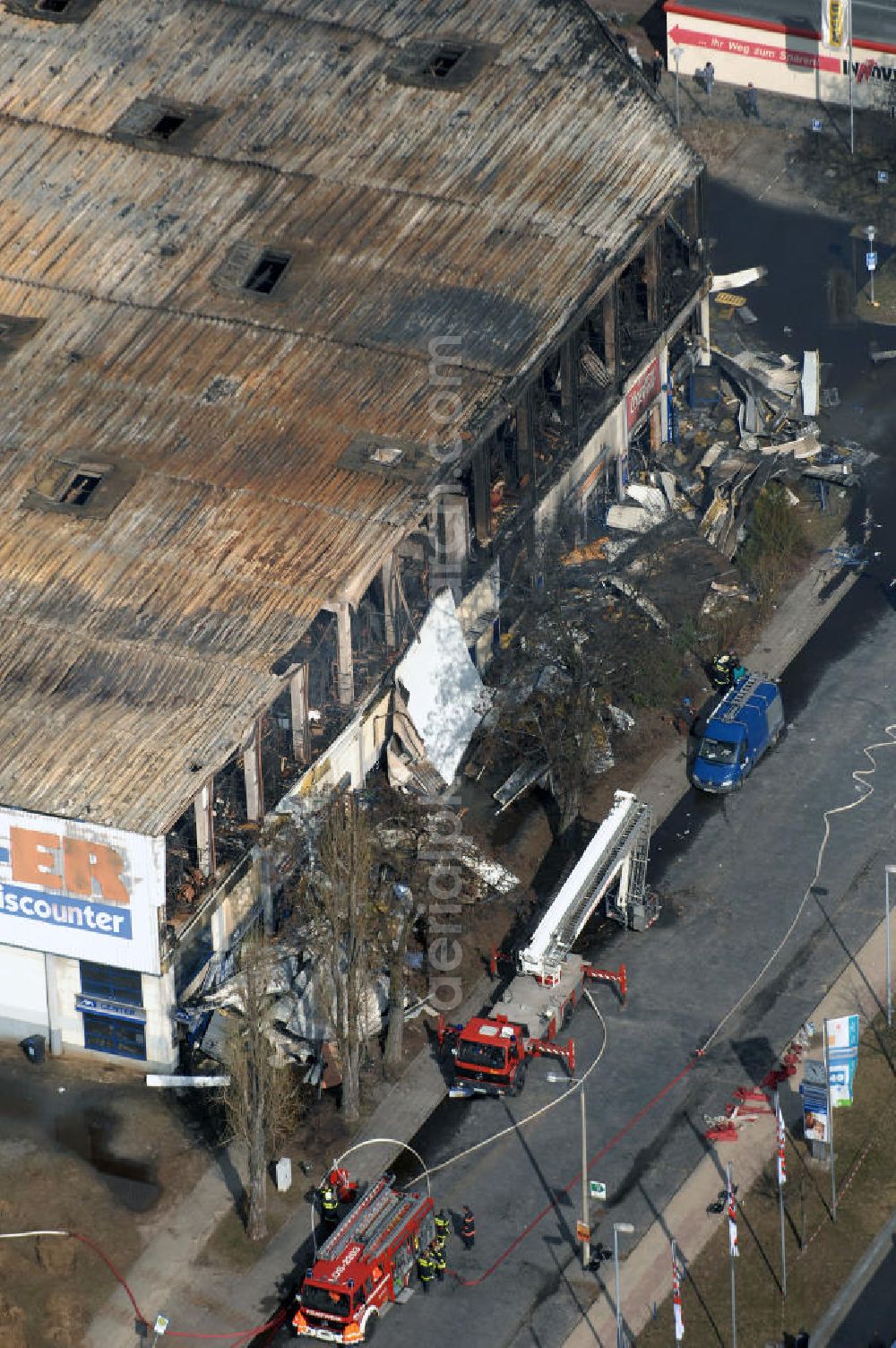 Eisenhüttenstadt from above - Blick auf ein Feuer / Brand / Großbrand im Einkaufszentrum Nordpassagen in Eisenhüttenstadt (ROLLER Möbeldiscounter). View of a large fire in the shopping center Nordpassagen in Eisenhüttenstadt.