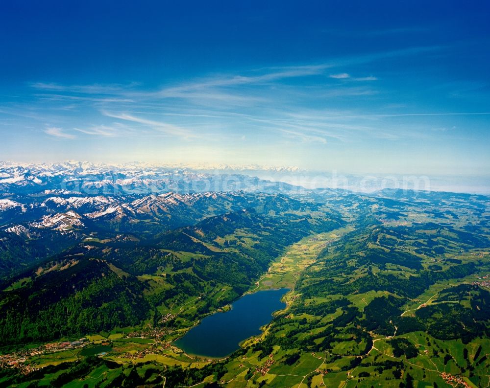 Aerial photograph Immenstadt - Grosser Alpsee (Large Alpine Lake) in Immenstadt in the state of Bavaria. Because of its location in a East-West running valley, the lake is a good sailing and surfing turf. The Austrian and Swiss Alps with its mountains and snow covered mountain-tops are located in the background