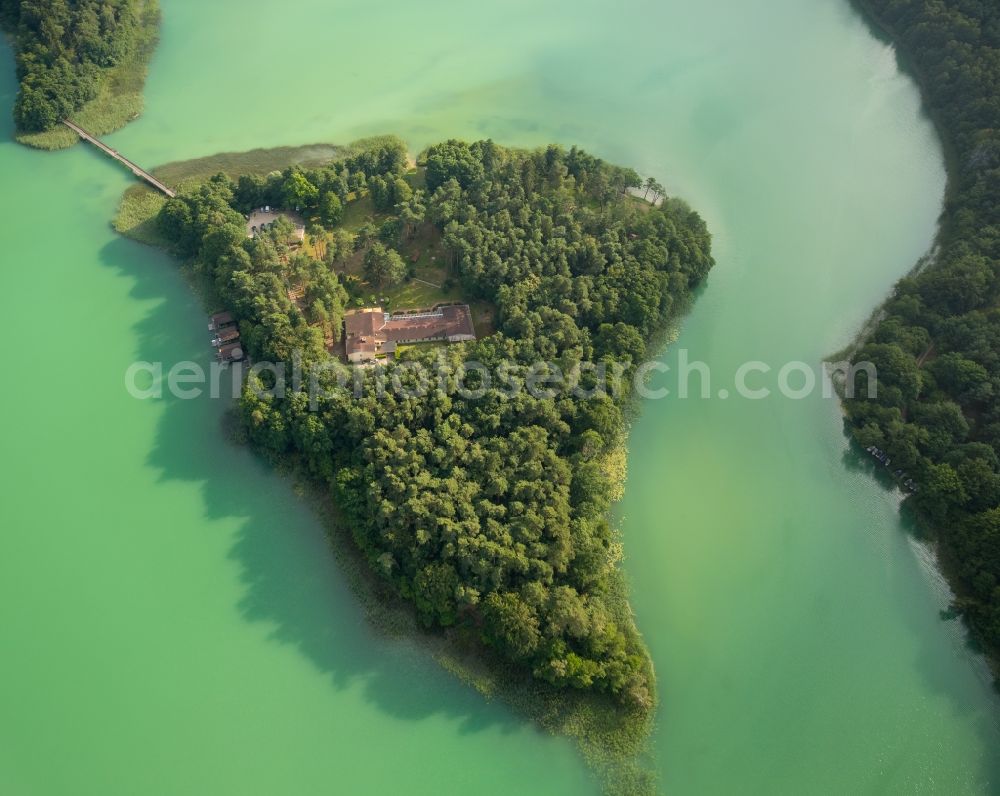 Aerial image Wokuhl-Dabelow - Lake Grosser Brueckentinsee with its island and green water in the nature park Feldberger Seenlandschaft in Wokuhl-Dabelow in the state of Mecklenburg - Western Pomerania. The Island Hotel Brueckentinsee is located on the island