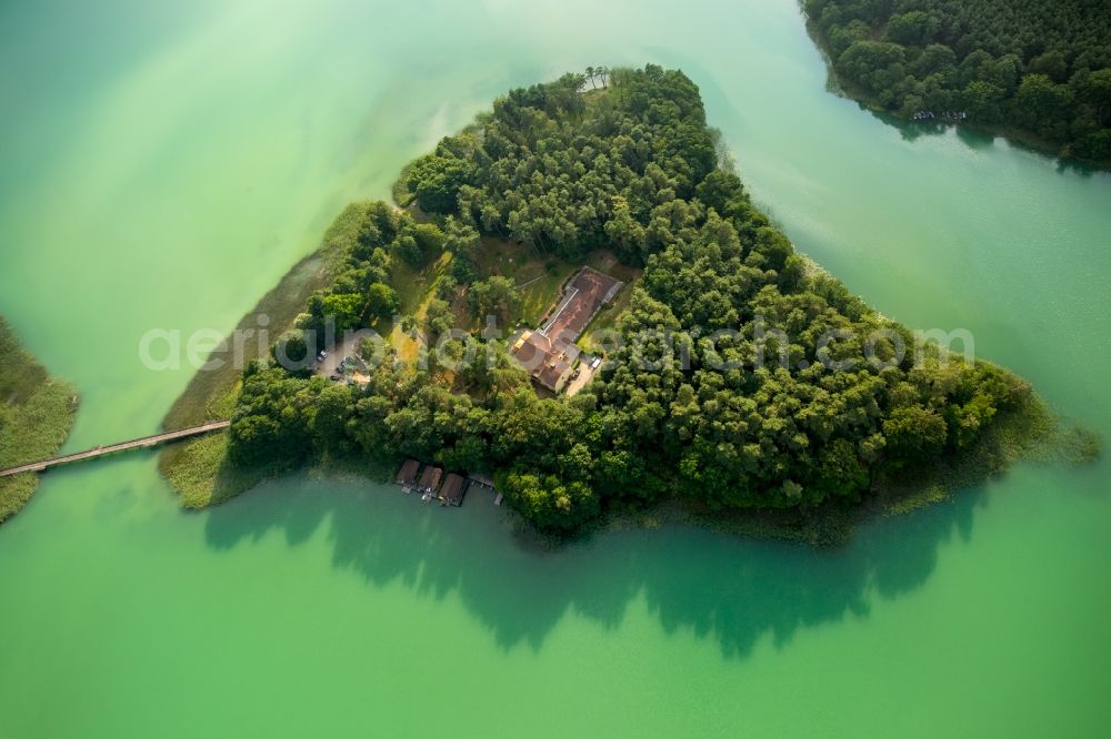 Aerial photograph Wokuhl-Dabelow - Lake Grosser Brueckentinsee with its island and green water in the nature park Feldberger Seenlandschaft in Wokuhl-Dabelow in the state of Mecklenburg - Western Pomerania. The Island Hotel Brueckentinsee is located on the island