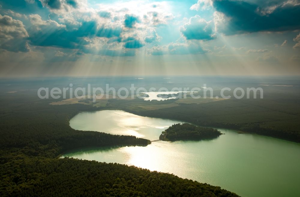 Wokuhl-Dabelow from the bird's eye view: Lake Grosser Brueckentinsee with its island and green water in the nature park Feldberger Seenlandschaft in Wokuhl-Dabelow in the state of Mecklenburg - Western Pomerania. The Island Hotel Brueckentinsee is located on the island