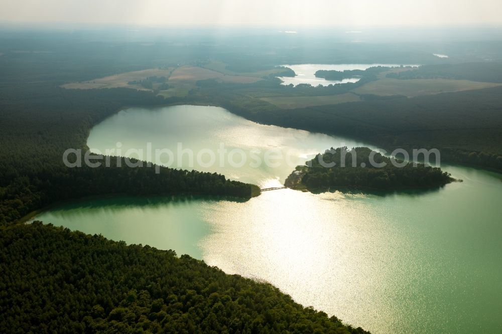 Aerial image Wokuhl-Dabelow - Lake Grosser Brueckentinsee with its island and green water in the nature park Feldberger Seenlandschaft in Wokuhl-Dabelow in the state of Mecklenburg - Western Pomerania. The Island Hotel Brueckentinsee is located on the island