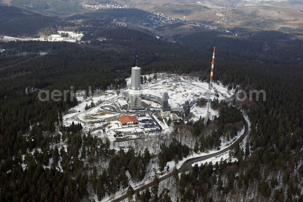 Aerial image Schmitten - Blick auf den winterlich mit Schnee bedeckte Großen Feldberg, der mit 881,5 m der höchste Berg des Mittelgebirges Taunus und des Rheinischen Schiefergebirges ist. Auf dem Gipfel befinden sich ein Fernmeldeturm, ein Rohrmast des Hessischen Rundfunks, der Aussichtsturm und die Gaststätte Feldberghof.