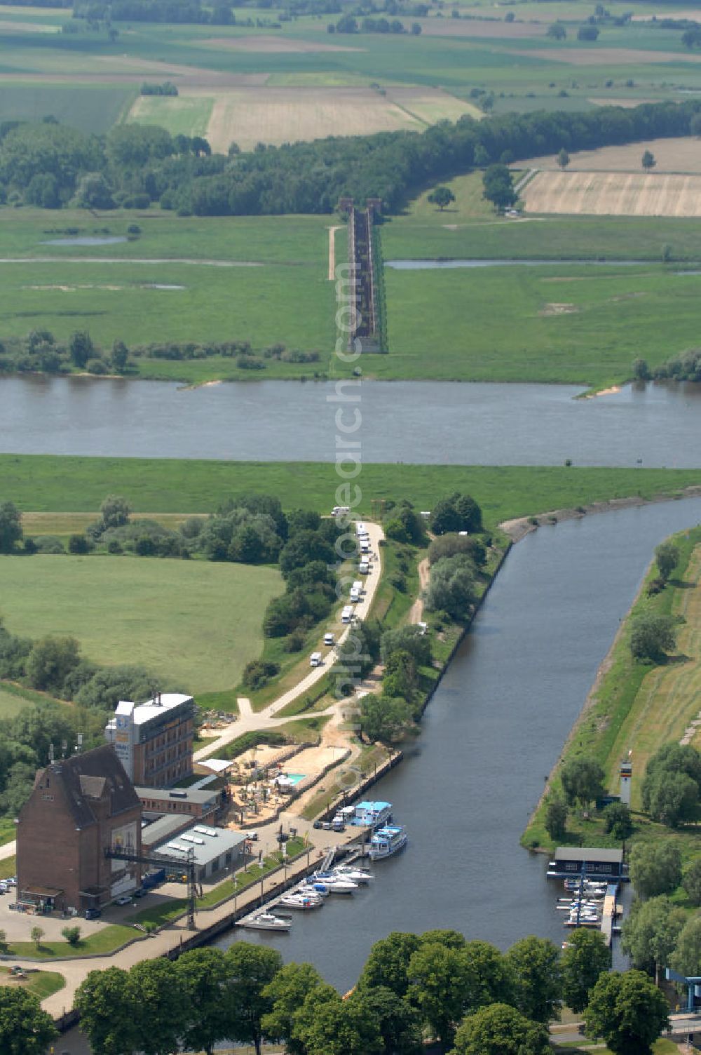 Dömitz from the bird's eye view: Blick auf den Hafen von Dömitz in Mecklenburg-Vorpommern. Die Stadt Dömitz an der Elbe liegt im Südwesten Mecklenburgs im Landkreis Ludwigslust. Der Hafen Dömitz bietet in den umgenutzten Speichergebäuden Erlebnisgastronomie mit einem Panorama Cafè, Fischrestaurant und Beachclub, sowie ein maritimes Hotel. Der Alte Speicher wird auch in der Saison für Kanu- oder Bootsverleih genutzt. Kontakt: Dömitzer Hafen Gastronomie GmbH & Co. KG, Hafenplatz 3, 19303 Dömitz, Tel.: 038758 / 364290,