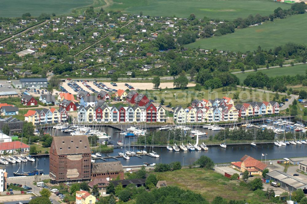 Aerial photograph Greifswald - Blick über den Hafen mit alten Speicher-Gebäuden und dem Fluss Ryck auf Mehrfamilienhäuser bzw. Einfamilienhäuser an der Deichstraße Ecke Holzteichstraße in Greifswald - Mecklenburg-Vorpommern MV. View onto the harbor / harbour with blocks of flats / appartment house or single-family houses in Greifswald - Mecklenburg-Western Pomerania.