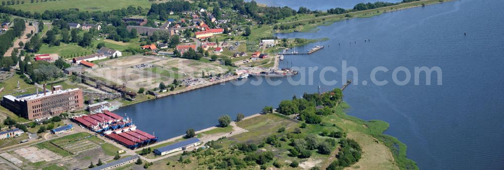 Peenemünde from the bird's eye view: Blick auf den Hafen Peenemünde und das Entwicklungsgebiet auf der ehemaligen Marinebasis auf der Insel Usedom. Das unter Denkmalschutz stehende alte Kraftwerk ist als Museum ein Touristenmagnet. Auf dem Gelände der ehemaligen NVA-Marinebasis entstehen nach umfassenden Abriß- und Räumungsarbeiten moderne Mehr- und Einfamilienhäuser. View of the Port Peenemünde and the development area on the former military base on the island of Usedom.