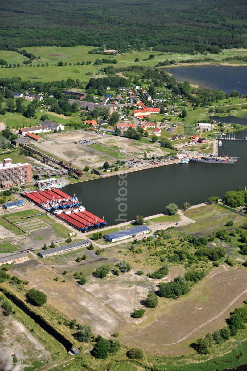 Aerial photograph Peenemünde - Blick auf den Hafen Peenemünde und das Entwicklungsgebiet auf der ehemaligen Marinebasis auf der Insel Usedom. Das unter Denkmalschutz stehende alte Kraftwerk ist als Museum ein Touristenmagnet. Auf dem Gelände der ehemaligen NVA-Marinebasis entstehen nach umfassenden Abriß- und Räumungsarbeiten moderne Mehr- und Einfamilienhäuser. View of the Port Peenemünde and the development area on the former military base on the island of Usedom.