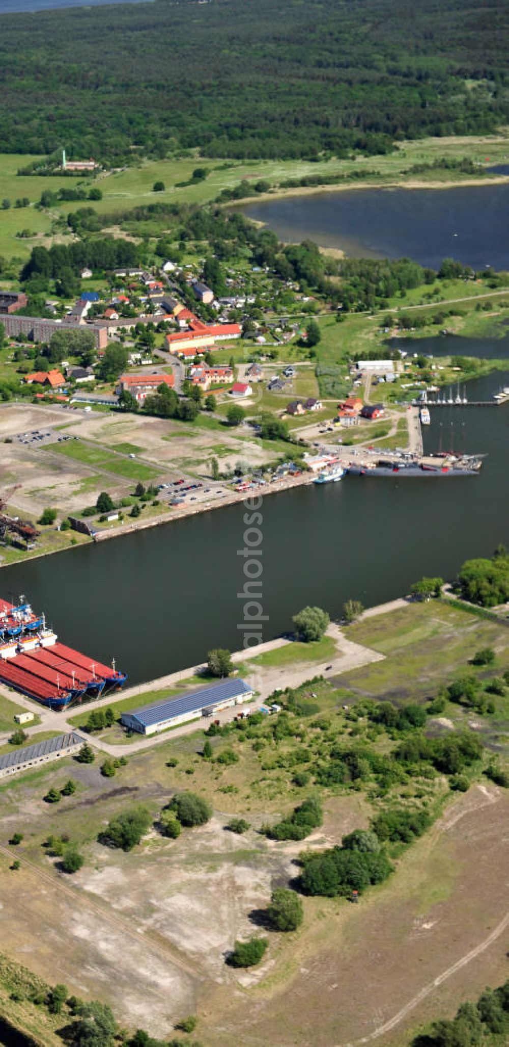 Peenemünde from above - Blick auf den Hafen Peenemünde und das Entwicklungsgebiet auf der ehemaligen Marinebasis auf der Insel Usedom. Das unter Denkmalschutz stehende alte Kraftwerk ist als Museum ein Touristenmagnet. Auf dem Gelände der ehemaligen NVA-Marinebasis entstehen nach umfassenden Abriß- und Räumungsarbeiten moderne Mehr- und Einfamilienhäuser. View of the Port Peenemünde and the development area on the former military base on the island of Usedom.