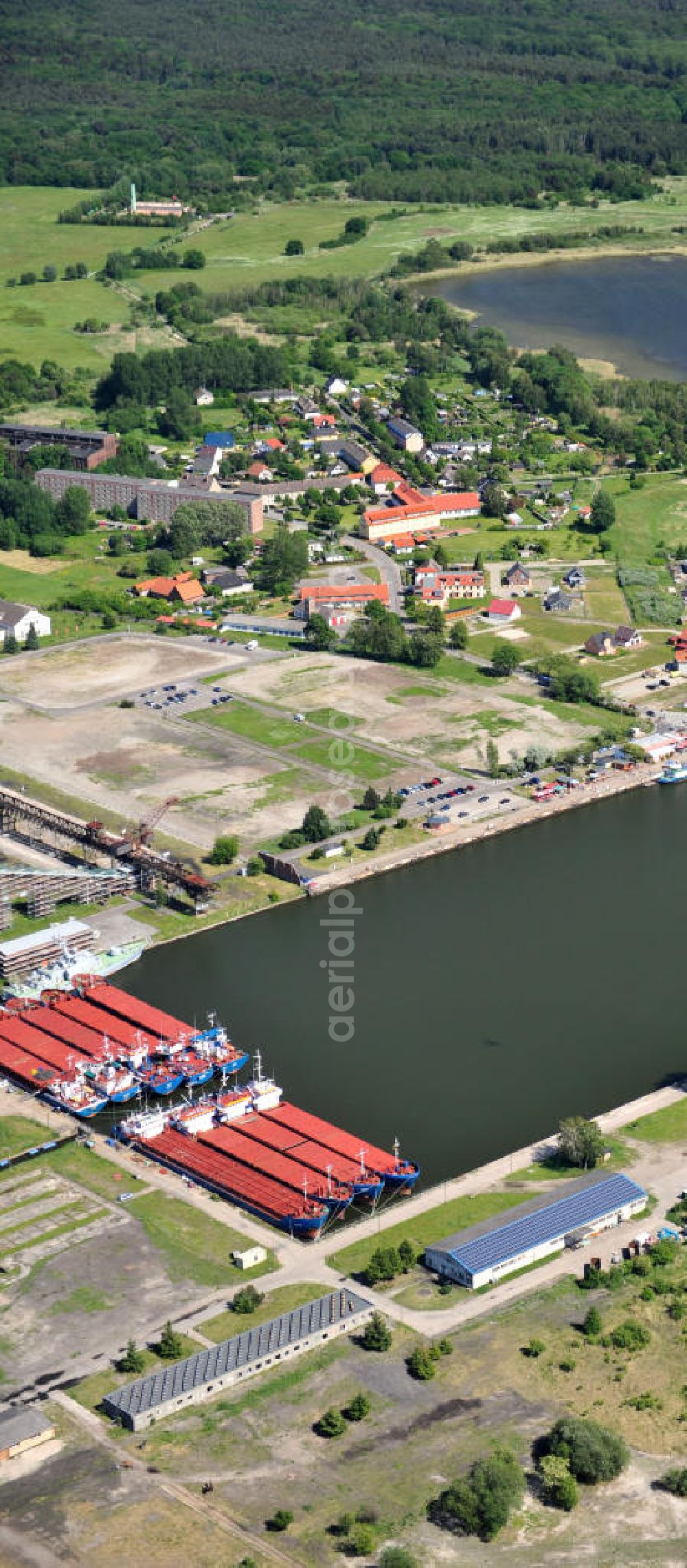 Aerial image Peenemünde - Blick auf den Hafen Peenemünde und das Entwicklungsgebiet auf der ehemaligen Marinebasis auf der Insel Usedom. Das unter Denkmalschutz stehende alte Kraftwerk ist als Museum ein Touristenmagnet. Auf dem Gelände der ehemaligen NVA-Marinebasis entstehen nach umfassenden Abriß- und Räumungsarbeiten moderne Mehr- und Einfamilienhäuser. View of the Port Peenemünde and the development area on the former military base on the island of Usedom.