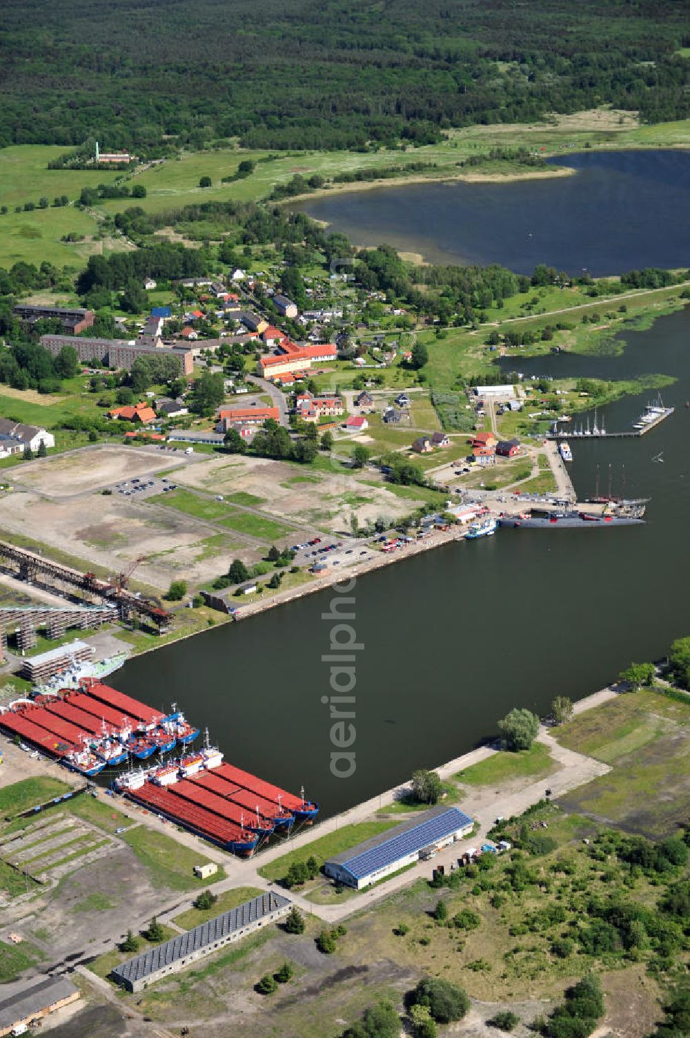 Aerial photograph Peenemünde - Blick auf den Hafen Peenemünde und das Entwicklungsgebiet auf der ehemaligen Marinebasis auf der Insel Usedom. Das unter Denkmalschutz stehende alte Kraftwerk ist als Museum ein Touristenmagnet. Auf dem Gelände der ehemaligen NVA-Marinebasis entstehen nach umfassenden Abriß- und Räumungsarbeiten moderne Mehr- und Einfamilienhäuser. View of the Port Peenemünde and the development area on the former military base on the island of Usedom.