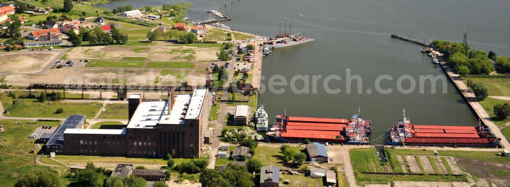 Aerial photograph Peenemünde - Blick auf den Hafen Peenemünde und das Entwicklungsgebiet auf der ehemaligen Marinebasis auf der Insel Usedom. Das unter Denkmalschutz stehende alte Kraftwerk ist als Museum ein Touristenmagnet. Auf dem Gelände der ehemaligen NVA-Marinebasis entstehen nach umfassenden Abriß- und Räumungsarbeiten moderne Mehr- und Einfamilienhäuser. View of the Port Peenemünde and the development area on the former military base on the island of Usedom.