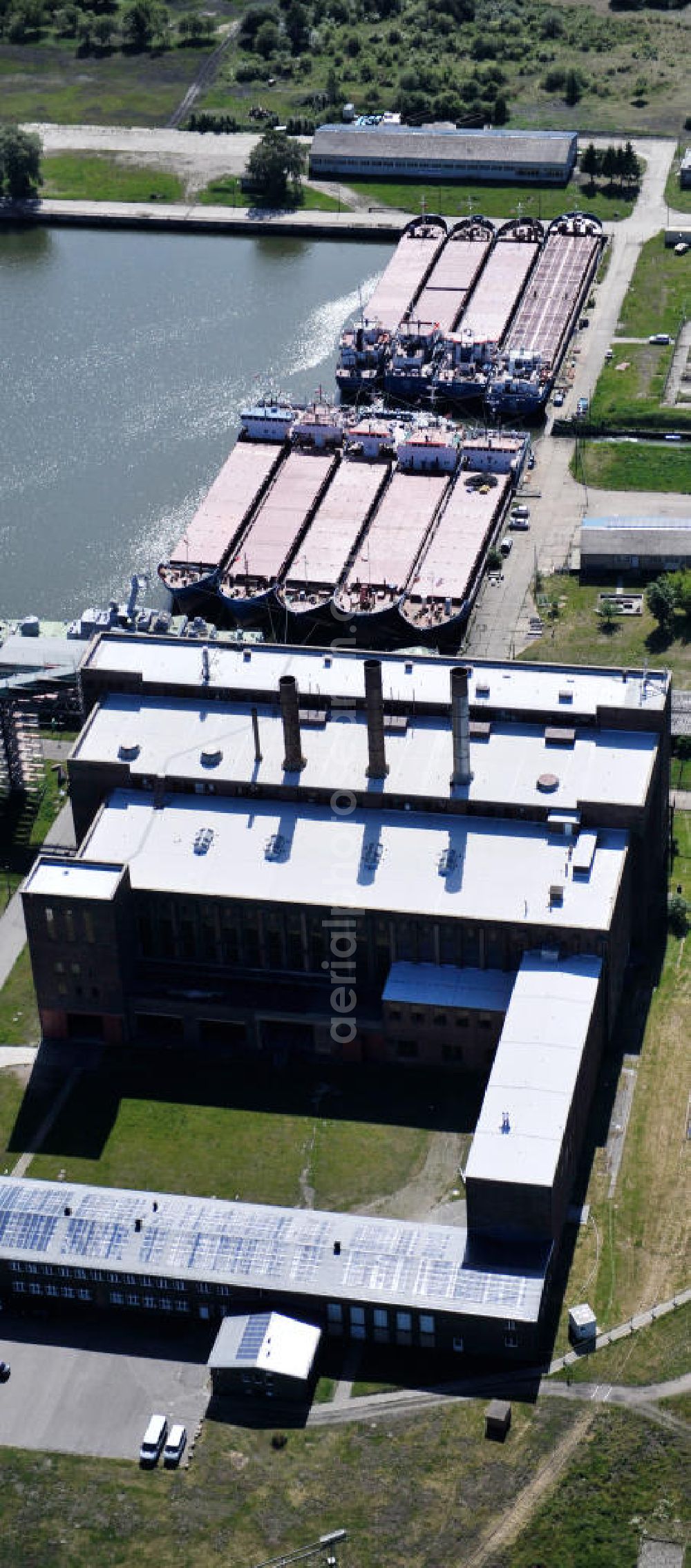 Peenemünde from the bird's eye view: Blick auf den Hafen Peenemünde und das Entwicklungsgebiet auf der ehemaligen Marinebasis auf der Insel Usedom. Das unter Denkmalschutz stehende alte Kraftwerk ist als Museum ein Touristenmagnet. Auf dem Gelände der ehemaligen NVA-Marinebasis entstehen nach umfassenden Abriß- und Räumungsarbeiten moderne Mehr- und Einfamilienhäuser. View of the Port Peenemünde and the development area on the former military base on the island of Usedom.