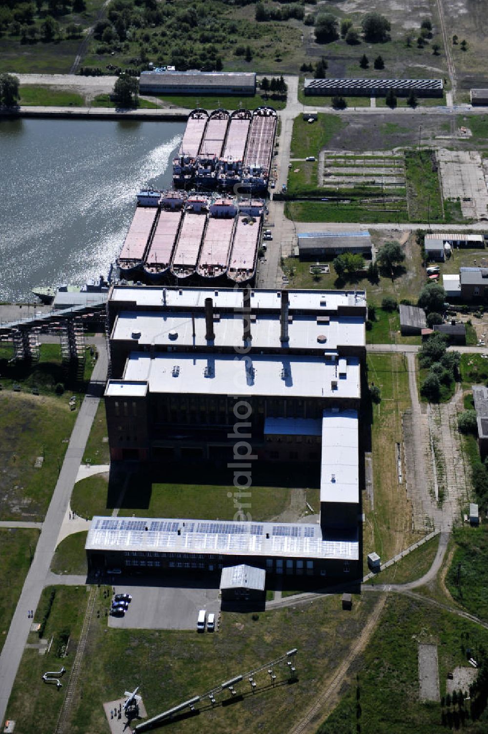 Aerial image Peenemünde - Blick auf den Hafen Peenemünde und das Entwicklungsgebiet auf der ehemaligen Marinebasis auf der Insel Usedom. Das unter Denkmalschutz stehende alte Kraftwerk ist als Museum ein Touristenmagnet. Auf dem Gelände der ehemaligen NVA-Marinebasis entstehen nach umfassenden Abriß- und Räumungsarbeiten moderne Mehr- und Einfamilienhäuser. View of the Port Peenemünde and the development area on the former military base on the island of Usedom.