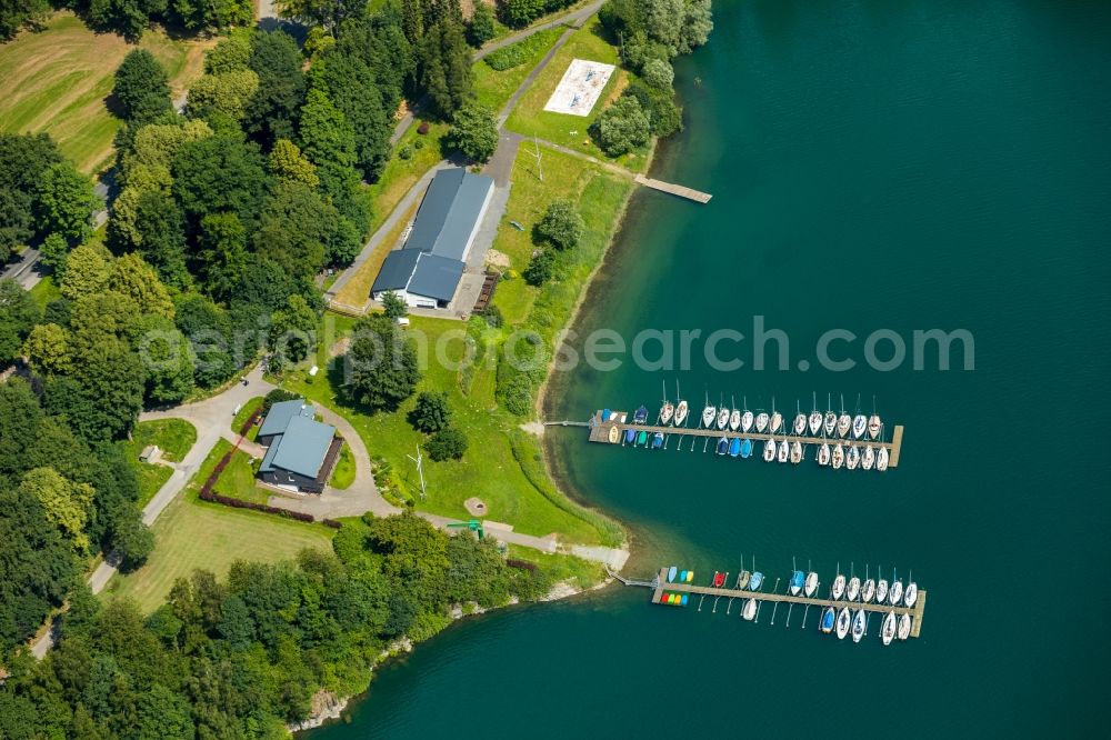 Meschede from the bird's eye view: Pleasure boat marina with docks and moorings on the shore area of Segel-Club Hennesee e.V. on Berghauser Bucht in Meschede in the state North Rhine-Westphalia, Germany