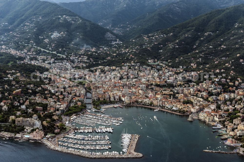 Aerial image Rapallo - View on the harbor and the city Rapallo with a row of houses on the shore of the river Milano on the Mediterranean coast in Liguria in Italy. Mountains of the Alps are visible in background