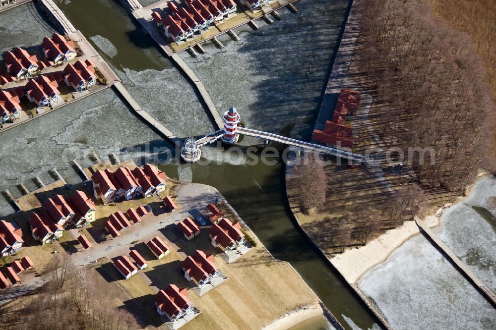 Rheinsberg from above - Der Hafeneingang des Hafendorfes an der Kaistraße am Rheinsberger See in der Nähe der Stadt Rheinsberg in Brandenburg. The harbour entrance of Holiday homes / vacation houses in the harbour / harbor village at the street Kaistrasse at the lake Rheinsberger See near the town Rheinsberg in Brandenburg.