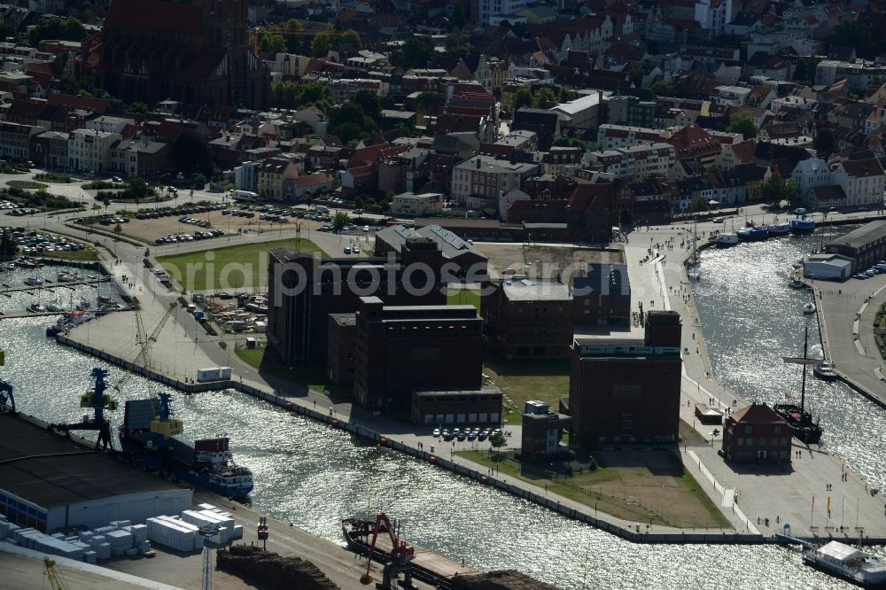 Aerial image Wismar - Docks and terminals with warehouses in Wismar in the state of Mecklenburg - Western Pomerania. The buildings, cranes and docks with wharf buildings are located on the Old Harbour, in the North of the historic town centre