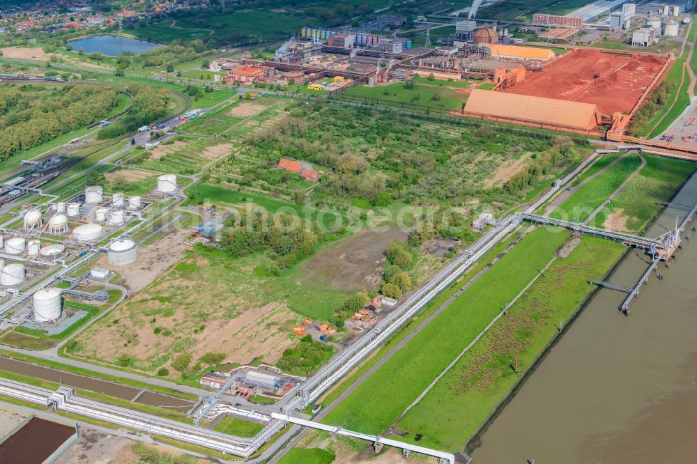 Stade from the bird's eye view: Port facility Stader Seehafen AOS am Buetzflether Sand in Buetzfleth in the state Lower Saxony, Germany. The Hanseatic Energy Hub is to be built on the green space by 2026. The planned terminal for the import of liquefied natural gas (LNG) will be integrated into the existing industrial park