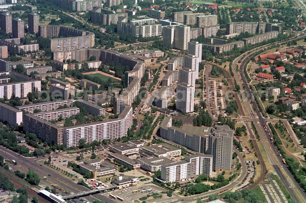 Berlin from the bird's eye view: Das Handelszentrum und Wohngebiet Marzahner Promenade in Berlin-Marzahn befindet sich in unmittelbarer Nähe zum S-Bahnhof Berlin-Marzahn. Neben dem zweigeschossigen Handelskomplex, zu dem Galerie Kaufhof gehörte, gibt es zahlreiche Einzelhandelsgeschäfte in den Erdgeschossen der Wohnblöcke entlang der Marzahner Promenade, die so zur zentralen Einkaufsstraße der Großblocksiedlung Marzahn wurde. //The commercial center and residential area in Berlin-Marzahn Marzahn Promenade is located in close proximity to Berlin-Marzahn S-Bahn station. In addition to the two-storey commercial complex, which belonged Gallery Kaufhof, there are numerous retail shops on the ground floors of apartment buildings along the promenade Marzahn, which thus became the central shopping street of big block settlement Marzahn