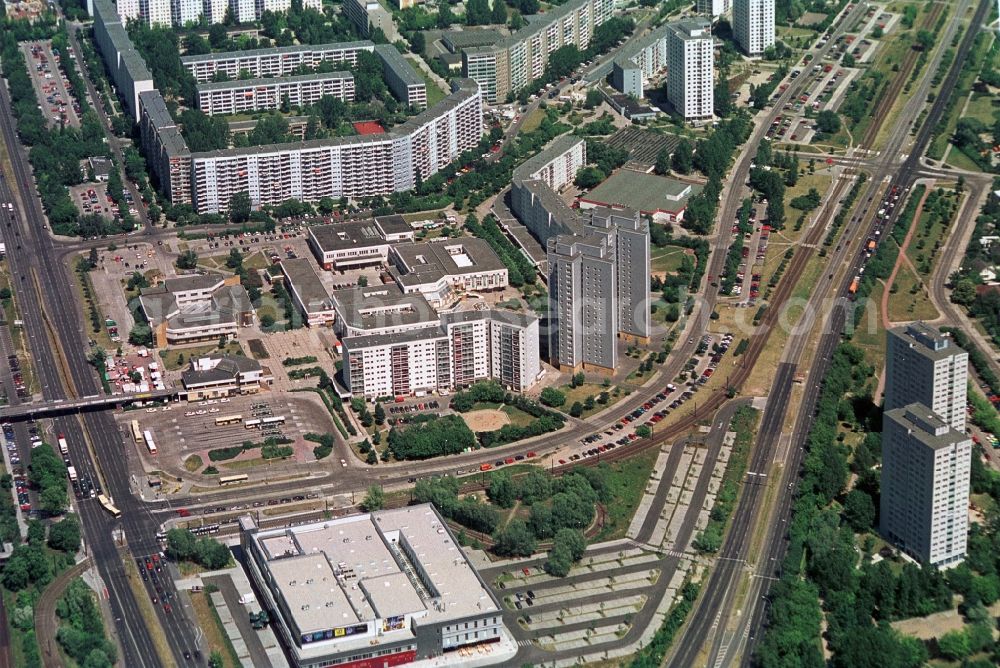 Aerial image Berlin - Das Handelszentrum und Wohngebiet Marzahner Promenade in Berlin-Marzahn befindet sich in unmittelbarer Nähe zum S-Bahnhof Berlin-Marzahn. Neben dem zweigeschossigen Handelskomplex, zu dem Galerie Kaufhof gehörte, gibt es zahlreiche Einzelhandelsgeschäfte in den Erdgeschossen der Wohnblöcke entlang der Marzahner Promenade, die so zur zentralen Einkaufsstraße der Großblocksiedlung Marzahn wurde. Südlich des Busbahnhofes wurde mit dem Le Prom einem UCI-Kino und einer Bowlingbahn eine kulturelle Einrichtung geschaffen. //The commercial center and residential area in Berlin-Marzahn Marzahn Promenade is located in close proximity to Berlin-Marzahn S-Bahn station. In addition to the two-storey commercial complex, which belonged Gallery Kaufhof, there are numerous retail shops on the ground floors of apartment buildings along the promenade Marzahn, which thus became the central shopping street of big block settlement Marzahn. South of the bus station was created with a UCI cinema and a bowling alley, a cultural institution