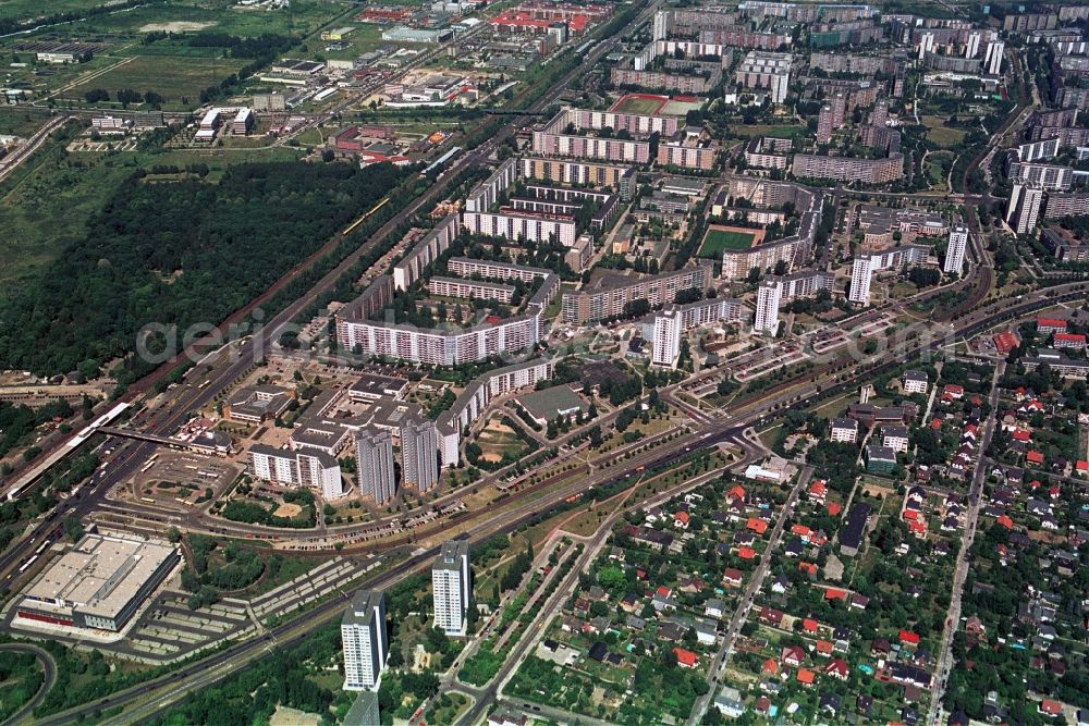 Aerial photograph Berlin - Das Handelszentrum und Wohngebiet Marzahner Promenade in Berlin-Marzahn befindet sich in unmittelbarer Nähe zum S-Bahnhof Berlin-Marzahn. Neben dem zweigeschossigen Handelskomplex, zu dem Galerie Kaufhof gehörte, gibt es zahlreiche Einzelhandelsgeschäfte in den Erdgeschossen der Wohnblöcke entlang der Marzahner Promenade, die so zur zentralen Einkaufsstraße der Großblocksiedlung Marzahn wurde. //The commercial center and residential area in Berlin-Marzahn Marzahn Promenade is located in close proximity to Berlin-Marzahn S-Bahn station. In addition to the two-storey commercial complex, which belonged Gallery Kaufhof, there are numerous retail shops on the ground floors of apartment buildings along the promenade Marzahn, which thus became the central shopping street of big block settlement Marzahn