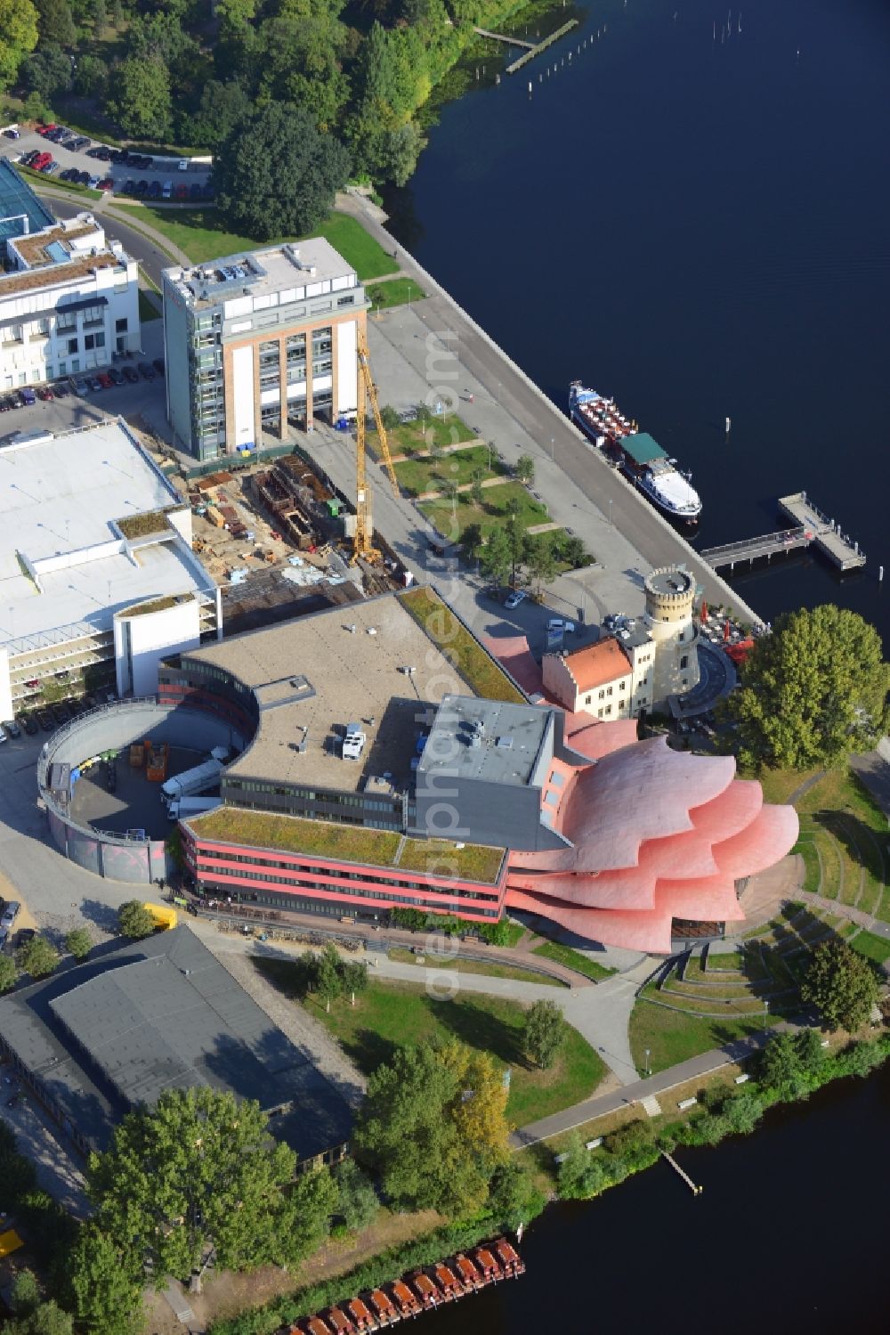 Aerial photograph Potsdam - Blick auf das Hans Otto Theater auf dem Kultur- und Gewerbestandort in der Schiffbauergasse am Ufer des Tiefen Sees in Potsdam. Das 2006 eröffnete Theater ist das Brandenburgischen Landestheaters, das vom Architekten Gottfried Böhm entworfen wurde. Vor dem Neubau steht der aus dem 19. Jahrhundert stammende Turm einer früheren Zichorienmühle, in dem ein Restaurant für gehobene Ansprüche untergebracht ist.