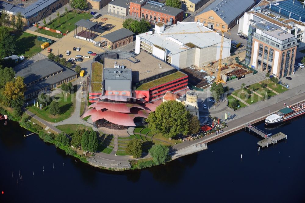 Potsdam from the bird's eye view: Blick auf das Hans Otto Theater auf dem Kultur- und Gewerbestandort in der Schiffbauergasse am Ufer des Tiefen Sees in Potsdam. Das 2006 eröffnete Theater ist das Brandenburgischen Landestheaters, das vom Architekten Gottfried Böhm entworfen wurde. Vor dem Neubau steht der aus dem 19. Jahrhundert stammende Turm einer früheren Zichorienmühle, in dem ein Restaurant für gehobene Ansprüche untergebracht ist.