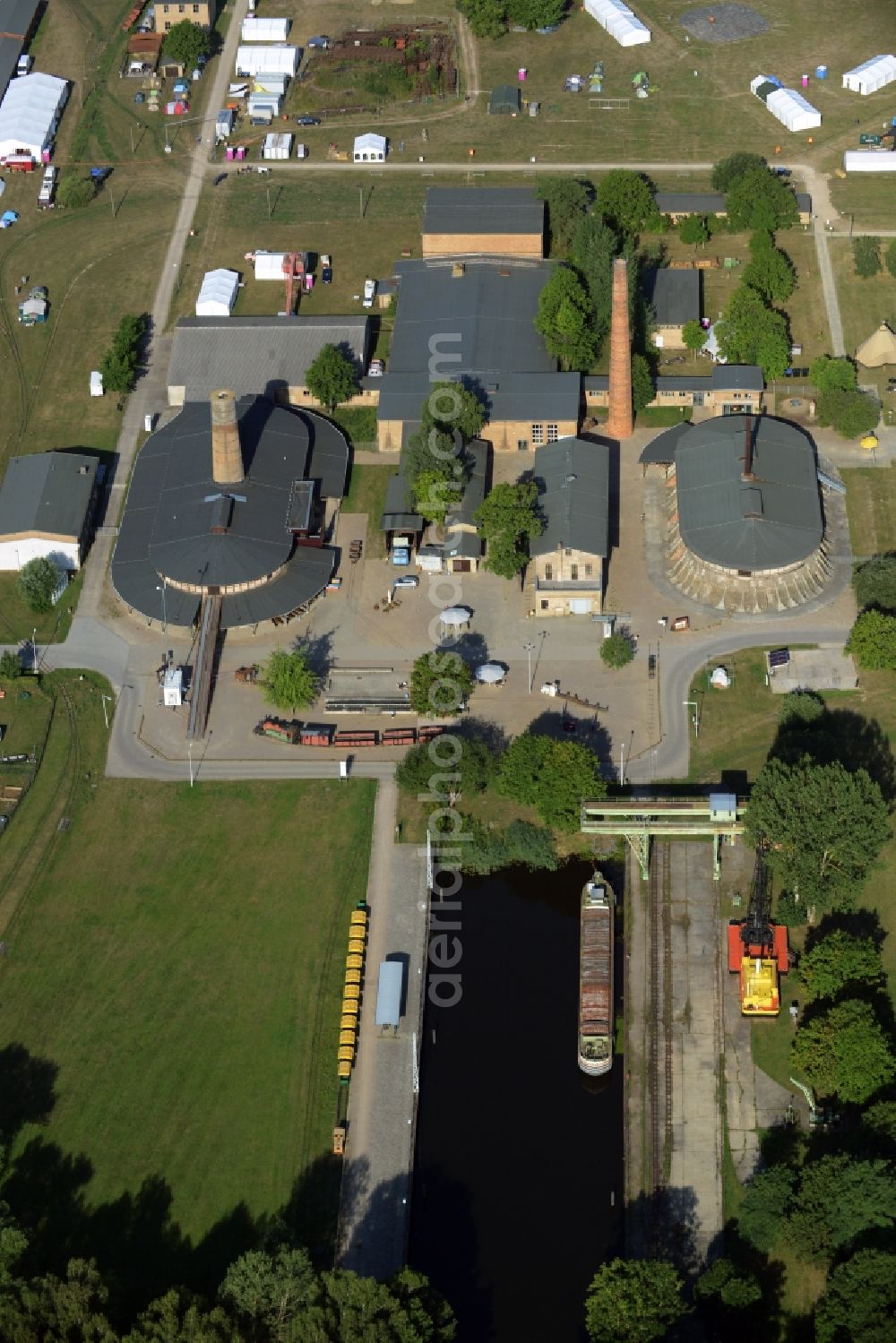 Zehdenick from the bird's eye view: Main buildings and technical facilities in the Mildenberg brick work park in the town area of Zehdenick in the state of Brandenburg. The park is an industrial memorial, surrounded by lakes and ponds. The compound consists of the company sites of two former brick works and is located in the North of the Mildenberg part of the town. View of the works, chimneys and factories of the compound