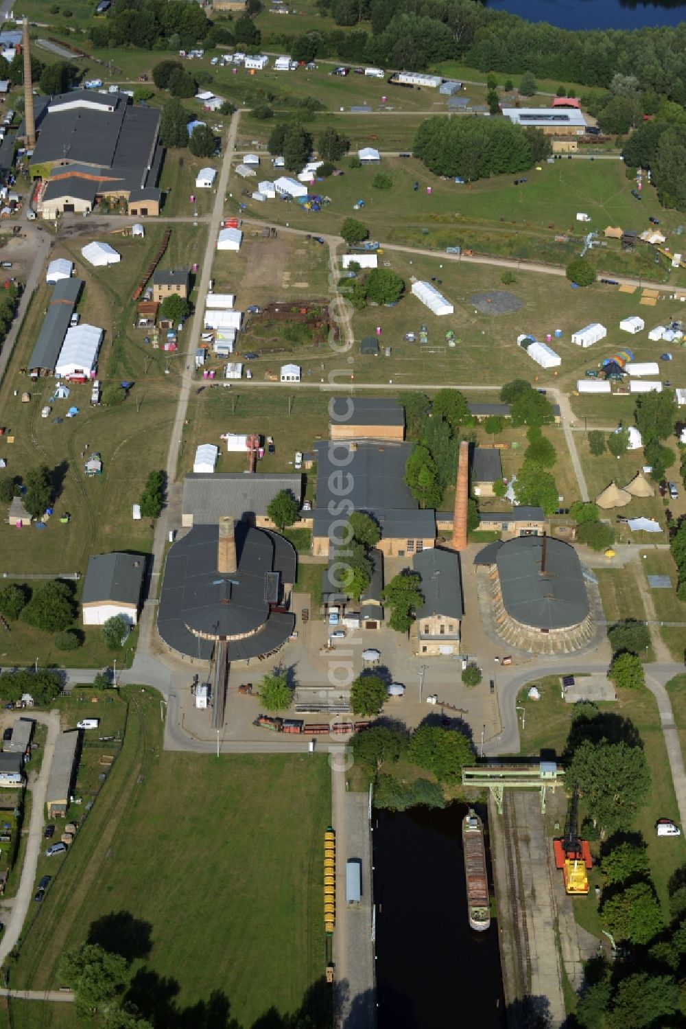 Aerial photograph Zehdenick - Main buildings and technical facilities in the Mildenberg brick work park in the town area of Zehdenick in the state of Brandenburg. The park is an industrial memorial, surrounded by lakes and ponds. The compound consists of the company sites of two former brick works and is located in the North of the Mildenberg part of the town. View of the works, chimneys and factories of the compound