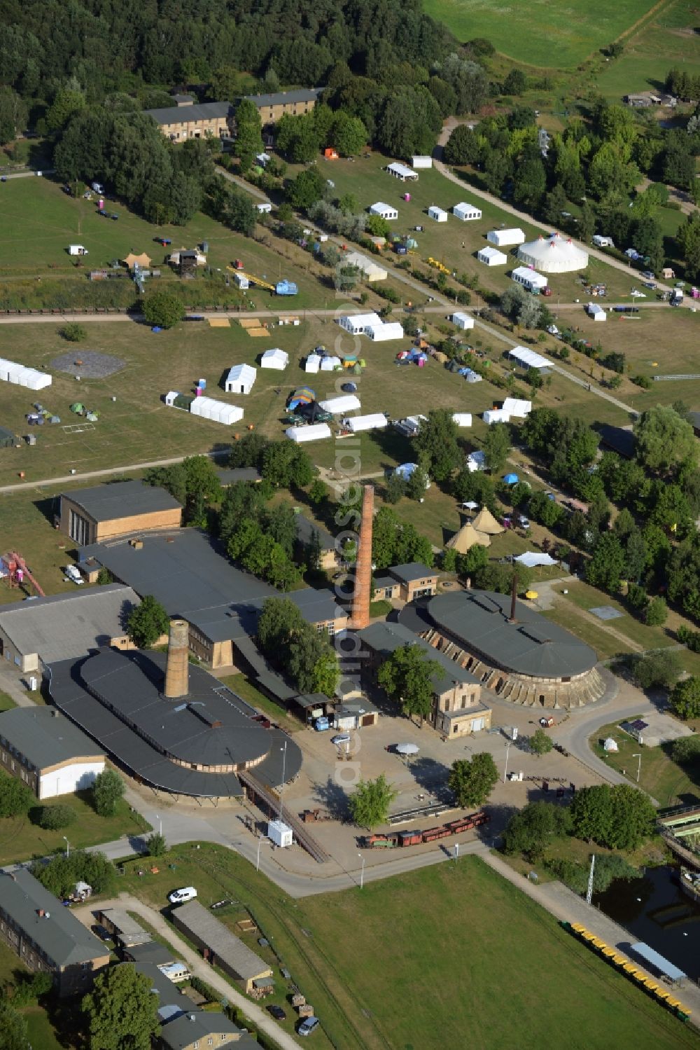 Zehdenick from the bird's eye view: Main buildings and technical facilities in the Mildenberg brick work park in the town area of Zehdenick in the state of Brandenburg. The park is an industrial memorial, surrounded by lakes and ponds. The compound consists of the company sites of two former brick works and is located in the North of the Mildenberg part of the town. View of the works, chimneys and factories of the compound