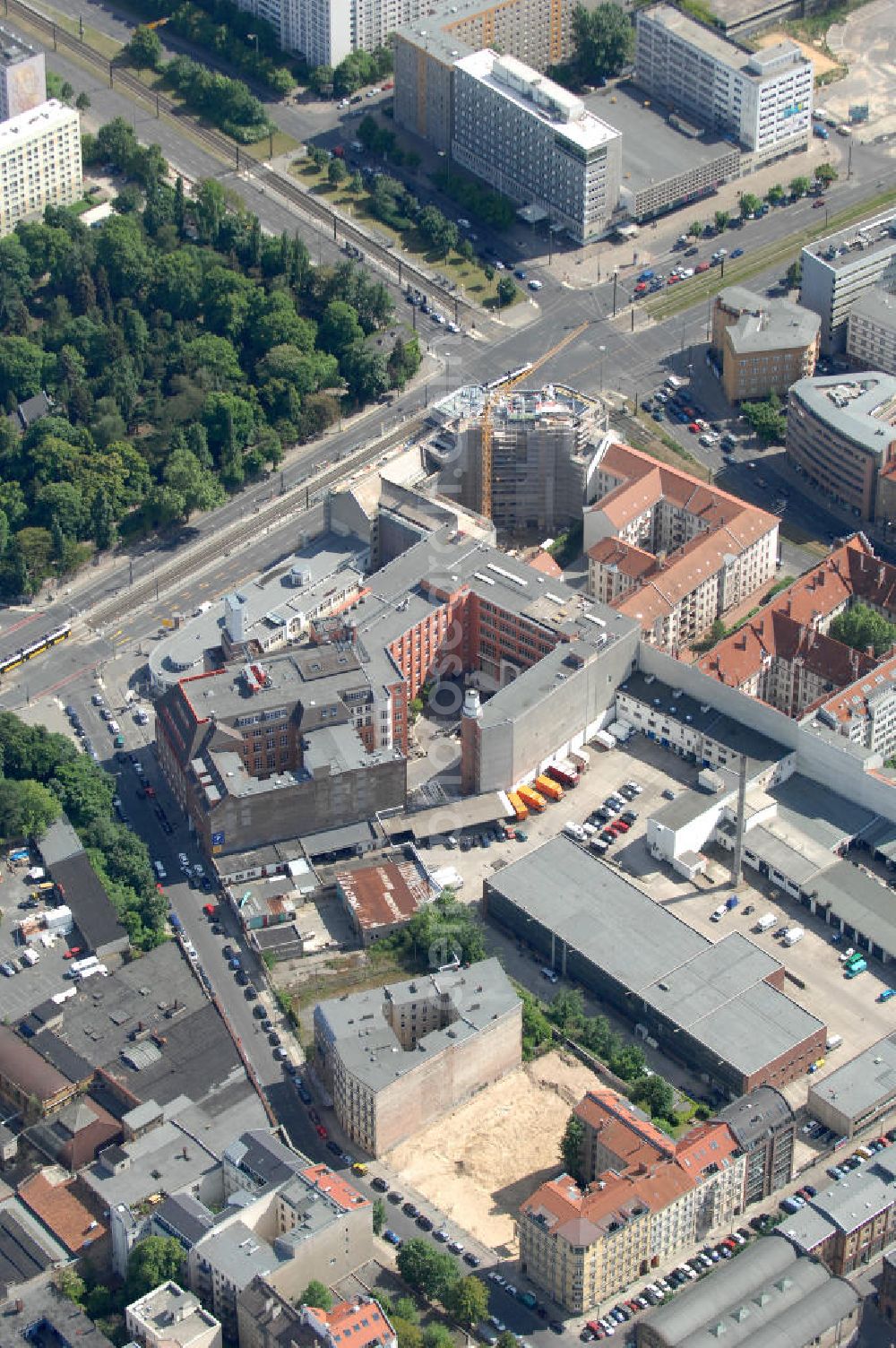 Berlin from the bird's eye view: Blick auf die Baustelle am Haus der Einheit, dem ehemaligen Kaufhauses Jonaß, es hat in Berlin hat eine wechselvolle Geschichte hinter sich, die auch eng mit der jüngeren deutschen Geschichte verbunden ist. Auf dem Gelände eines 1828 errichteten Exerzier- und Reithauses baute der jüdische Kaufmann Hermann Golluber in den Jahren 1928/29 das sechsgeschossige Kaufhaus Kredit-Warenhaus Jonaß & Co AG. Das Gebäude in der damaligen Lothringer Straße 1 wurde von den Architekten Georg Bauer und Siegfried Friedländer in der Ende der 1920er Jahre aufkommenden Skelettbauweise im Stil der Neuen Sachlichkeit geplant und errichtet. Über einen zweigeschossigen mit Naturstein verkleideten Sockel schließt sich ein fünfgeschossiger Putzbau und ein Dachgeschoss an, in dem über einige Jahre ein Dachrestaurant betrieben wurde. Unmittelbar nach Ende des Zweiten Weltkrieges wurde das Gebäude verstaatlicht und Sitz des Zentralausschusses der SPD. Nach deren Vereinigung mit der KPD zur SED wurde es 1946 Sitz des Zentralkomitees der SED. Zwei in den Jahren 1976 und 1988 angebrachte Tafeln am Haupteingang des Gebäudes erinnern heute noch daran, dass der erste (und einzige) DDR-Präsident Wilhelm Pieck und sein Ministerpräsident Otto Grotewohl in dem Gebäude ihre Arbeitsräume hatten. In Hinblick auf den Zusammenschluss zwischen KPD und SPD erhielt es nun den Namen Haus der Einheit. Von 1956 bis 1990 war im Haus das Geschichtsinstitut beim ZK der SED ansässig, zu dem auch das historische Archiv der KPD und das Zentrale Parteiarchiv der SED gehörten. Das seit 1995 leer stehende Haus wurde nach langwierigen Verhandlungen mit den Vertretern der in aller Welt verstreuten jüdischen Erben im Januar an einen britischen Investor verkauft. Dieser hat das Berliner Architektur-Büro JSK mit der Umbauplanung des markanten, teilweise unter Denkmalschutz stehenden Gebäudes beauftragt.