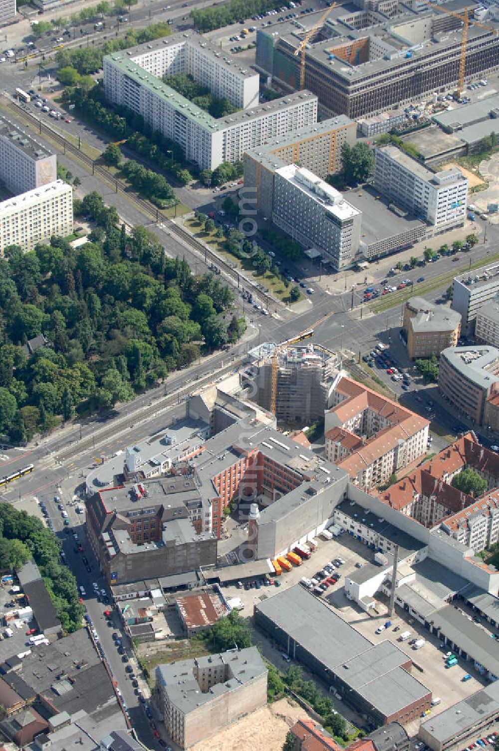 Aerial image Berlin - Blick auf die Baustelle am Haus der Einheit, dem ehemaligen Kaufhauses Jonaß, es hat in Berlin hat eine wechselvolle Geschichte hinter sich, die auch eng mit der jüngeren deutschen Geschichte verbunden ist. Auf dem Gelände eines 1828 errichteten Exerzier- und Reithauses baute der jüdische Kaufmann Hermann Golluber in den Jahren 1928/29 das sechsgeschossige Kaufhaus Kredit-Warenhaus Jonaß & Co AG. Das Gebäude in der damaligen Lothringer Straße 1 wurde von den Architekten Georg Bauer und Siegfried Friedländer in der Ende der 1920er Jahre aufkommenden Skelettbauweise im Stil der Neuen Sachlichkeit geplant und errichtet. Über einen zweigeschossigen mit Naturstein verkleideten Sockel schließt sich ein fünfgeschossiger Putzbau und ein Dachgeschoss an, in dem über einige Jahre ein Dachrestaurant betrieben wurde. Unmittelbar nach Ende des Zweiten Weltkrieges wurde das Gebäude verstaatlicht und Sitz des Zentralausschusses der SPD. Nach deren Vereinigung mit der KPD zur SED wurde es 1946 Sitz des Zentralkomitees der SED. Zwei in den Jahren 1976 und 1988 angebrachte Tafeln am Haupteingang des Gebäudes erinnern heute noch daran, dass der erste (und einzige) DDR-Präsident Wilhelm Pieck und sein Ministerpräsident Otto Grotewohl in dem Gebäude ihre Arbeitsräume hatten. In Hinblick auf den Zusammenschluss zwischen KPD und SPD erhielt es nun den Namen Haus der Einheit. Von 1956 bis 1990 war im Haus das Geschichtsinstitut beim ZK der SED ansässig, zu dem auch das historische Archiv der KPD und das Zentrale Parteiarchiv der SED gehörten. Das seit 1995 leer stehende Haus wurde nach langwierigen Verhandlungen mit den Vertretern der in aller Welt verstreuten jüdischen Erben im Januar an einen britischen Investor verkauft. Dieser hat das Berliner Architektur-Büro JSK mit der Umbauplanung des markanten, teilweise unter Denkmalschutz stehenden Gebäudes beauftragt.