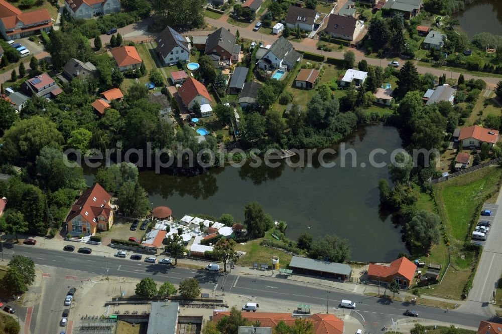 Aerial image Hoppegarten - Hechtsee lake in Hoppegarten in the state of Brandenburg. The lake is located on the edge of a residential area on Mahsldorfer Strasse. The restaurant Hechtsee Terrassen is located on its western shore