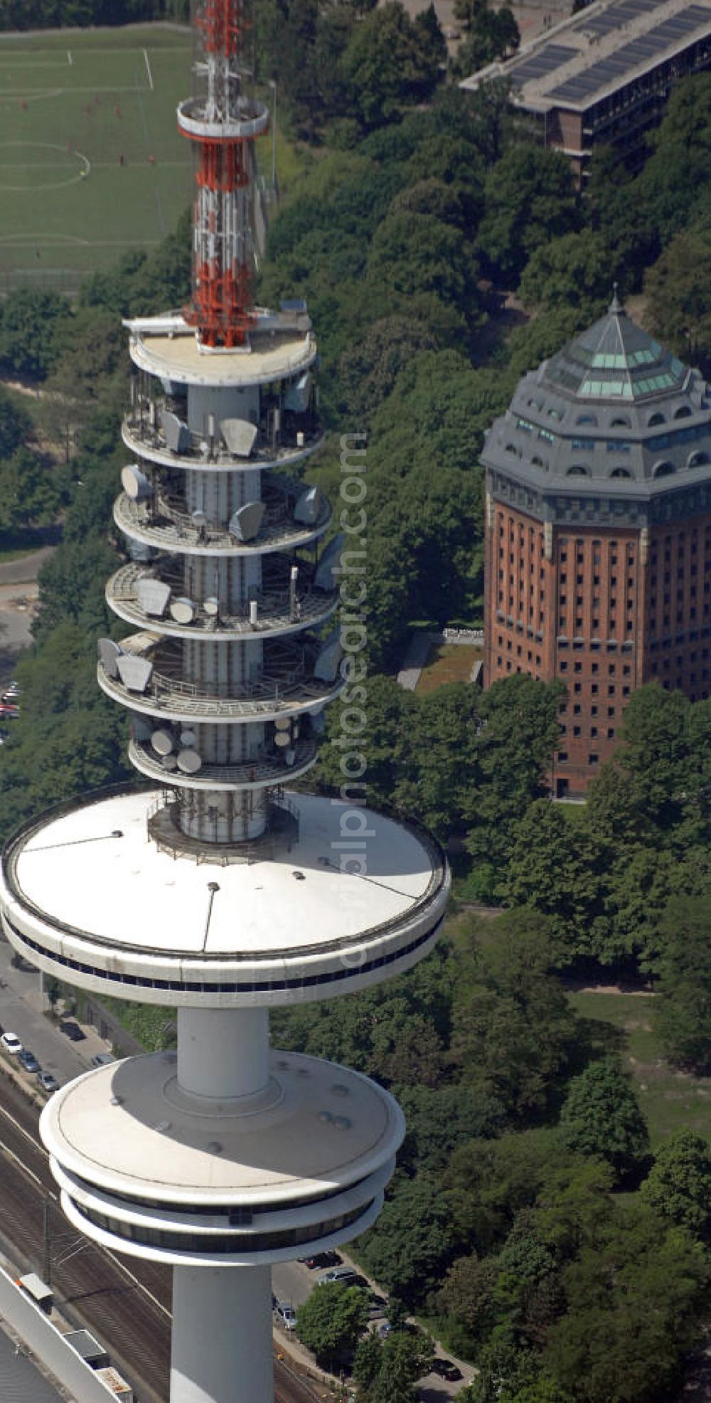 Hamburg from the bird's eye view: Blick auf den Fernmeldeturm Heinrich-Hertz-Turm am Messe-Gelände mit dem Schanzenturm im Hintergrund. Umgangssprachlich wird der 279 Meter hohe Fernmeldeturm auch Fernsehturm oder Tele-Michel genannt und ist eines der Wahrzeichen Hamburgs. Der Schanzenturm befindet sich im Sternschanzenpark und ist mit 57,5 Meter der ehemals größte Wasserturm Europas. Heute befindet sich das Mövenpick Hotel Hamburg im Schanzenturm. View of the telecommunications tower Heinrich-Hertz-Tower at the trade fair grounds and the Schanzenturm in the background. Colloquially, the 279-meter-high communications tower is called TV tower or tele-Michel and is one of the landmarks of Hamburg. The Schanzenturm is located in Sternschanzenpark and is with 57.5 meters the formerly largest water tower in Europe. Today, the Mövenpick Hotel Hamburg is located in the Schanzenturm.