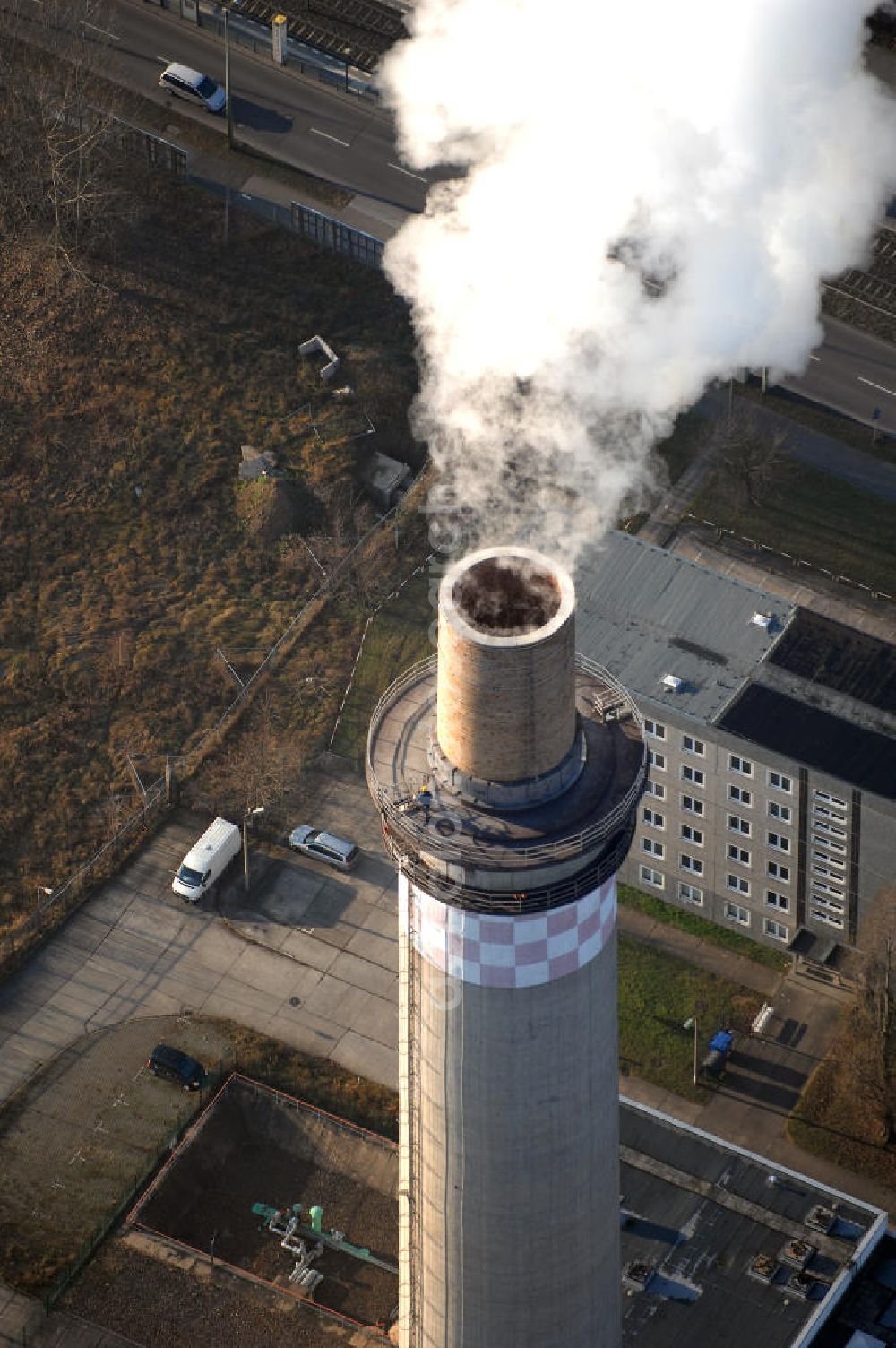 Berlin-Lichtenberg from above - Das Heizkraftwerk Berlin-Lichtenberg (HKW) wurde ab 1970 in mehreren Baustufen vom damaligen Energiekombinat Berlin errichtet. Damit wurde die Bebauung eines 405 Hektar großen Gebietes mit Industriestandorten begonnen, zu deren Versorgung das Kraftwerk dienen sollte. Außerdem wurde in dieser Zeit auch mit der Errichtung der neuen Wohngebiete rund um das Dorf Marzahn begonnen, die mit Fernwärme aus dem Kraftwerk beheizt werden sollten. Da das Gebiet zu dieser Zeit noch zum Stadtbezirk Lichtenberg gehörte, der zu dieser Zeit vom heutigen gleichnamigen Ortsteil bis zum östlichen Stadtrand reichte, wurde das Kraftwerk nach ihm benannt. Auch nach der Bildung des neuen Stadtbezirks Marzahn im Jahr 1979 wurde die Bezeichnung für das Kraftwerk beibehalten.Mit dem Zusammenschluss der aus dem Energiekombinat Berlin hervorgegangen EBAG und der Bewag (heute Vattenfall Europe Berlin) im Jahr 1993 wurde das Kraftwerk in das nunmehrige Gesamtberliner Strom- und Wärmenetz integriert. Es bildet heute einen Teil des Geschäftsbereichs Kraftwerke Ost.