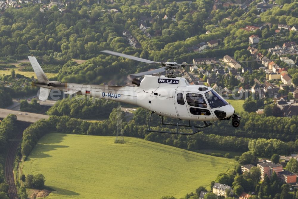 Witten from the bird's eye view: Helicopter HELI AG with the registration D-HAUP when shooting in flight over Witten in the state of North Rhine-Westphalia