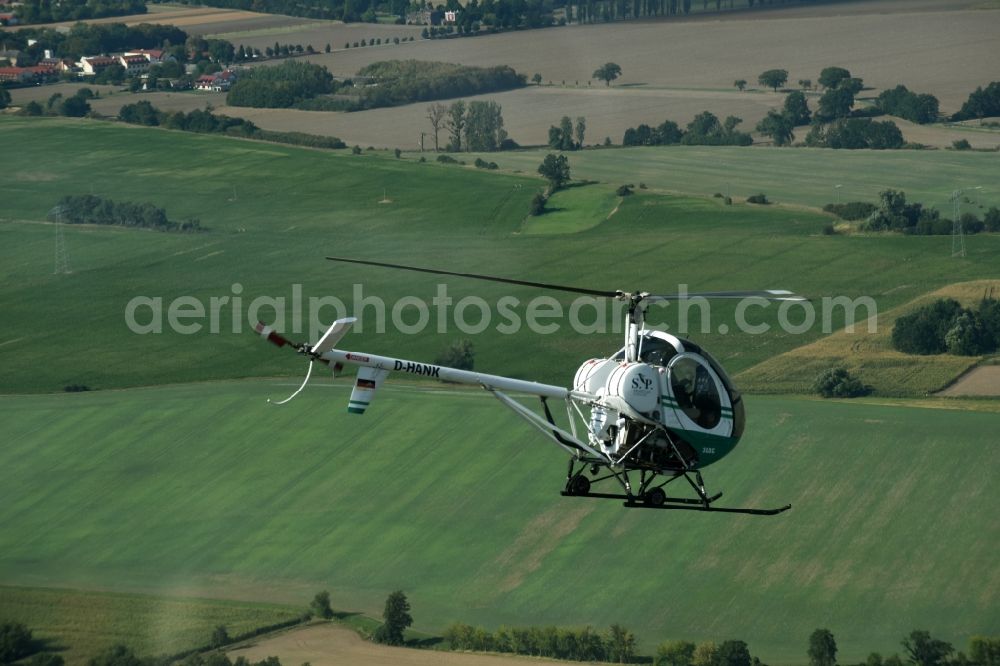 Aerial photograph Riesigk - Helicopter in flight Hughes 300 - Schweizer 300C call sign D-HANK over the air space in Riesigk in the state Saxony-Anhalt