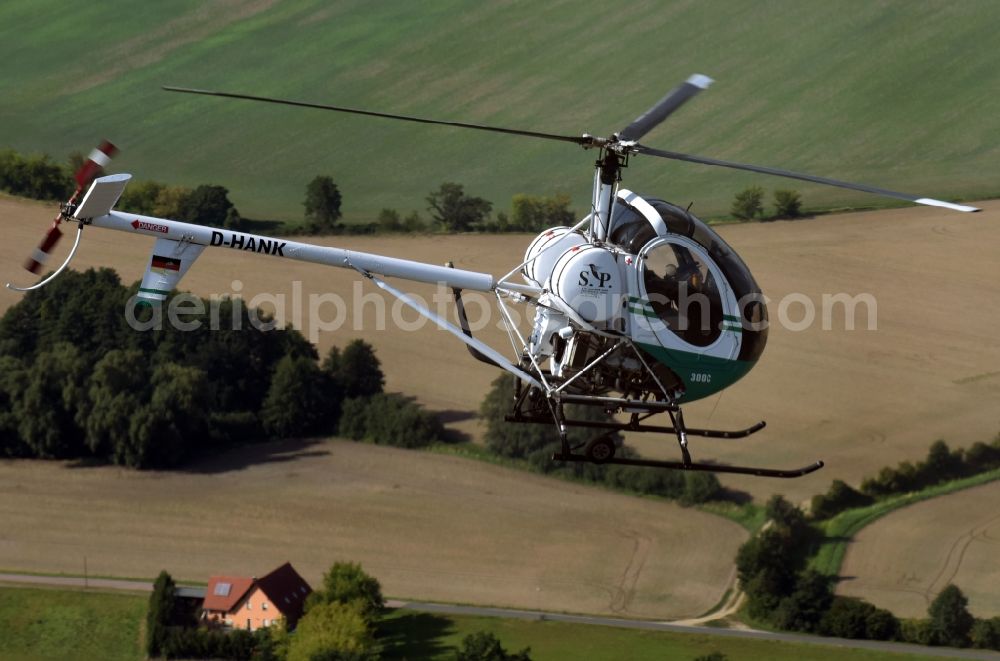 Aerial image Riesigk - Helicopter in flight Hughes 300 - Schweizer 300C call sign D-HANK over the air space in Riesigk in the state Saxony-Anhalt