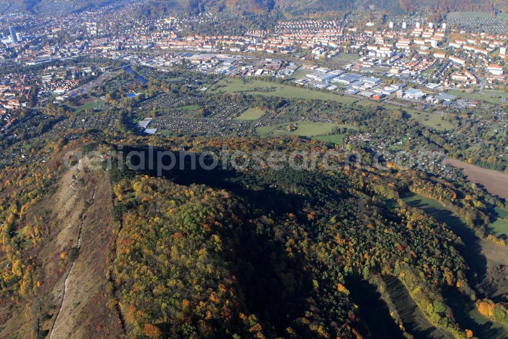 Jena from the bird's eye view: Autumn colored trees on the slopes of the mountains and a view of the core city of Jena in Thuringia