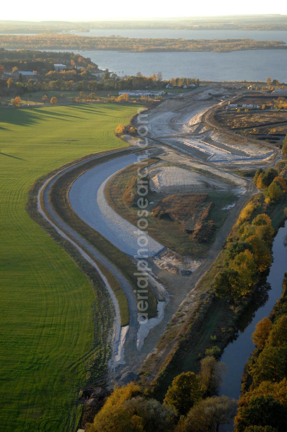 Großkoschen from above - Blick auf die herbstliche Baustelle eines Überleiters vom Senftenberger See zum Geierswalder See. Das Lausitzer Seenland mit seinen zehn Bergbaufolgeseen soll mit 13 Überleitern in ein schiffbares mit allen Seen verbundenes Seengebiet zusammengeführt werden. Beim Projekt Überleiter 12 erfolgt die Verbindung zwischen den beiden Seen mittels zweier Tunnel / Unterquerung zum einen der Bundesstraße B 96 und zum an deren des noch zu verlegendem Wasserlaufs der Schwarzen Elster. Am Oberen Vorhafen erfolgt der Bau einer Schleuse / Schlausenanlage. Kontakt: Lausitzer und Mitteldeutsche Bergbau-Verwaltungsgesellschaft mbH, LMBV, Abteilung Liegenschaften Lausitz, Dr. Bernd Krüger, Abteilungsleiter, Tel. +49(0)3573 844-210, Fax +49(0)3573 844-602, bernd.krueger@lmbv.de; Kontakt Bauausführung: Strabag AG Direktion Straßenbau Berlin-Brandenburg, Bereich Lausitz, Güterbahnhofstraße o. Nr., 01968 Senftenberg, Tel. +49(0)3573 3723-0, Fax +49(0)3573 3723-40, ber-sb-lausitz@strabag.com