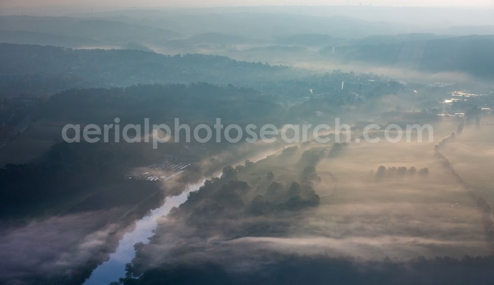 Essen from the bird's eye view: Autumnal landscape and morning atmosphere above the fog covered Mintarder Ruhrauen near Kettwig in the state of North Rhine-Westphalia